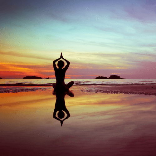 Woman doing Yoga on the beach.