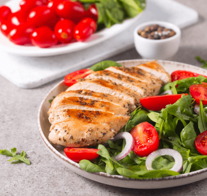 A plate of chicken on a salad.