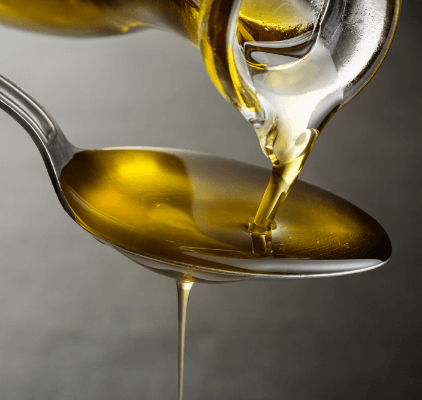 Olive oil being poured onto a spoon.