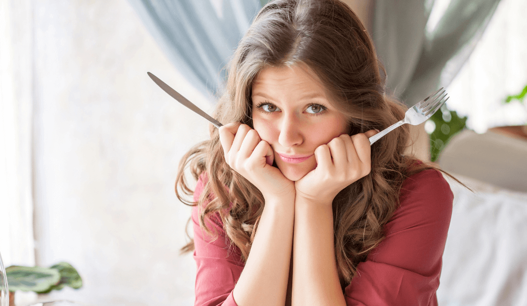 Hungry woman sits at a table and waits for her food.