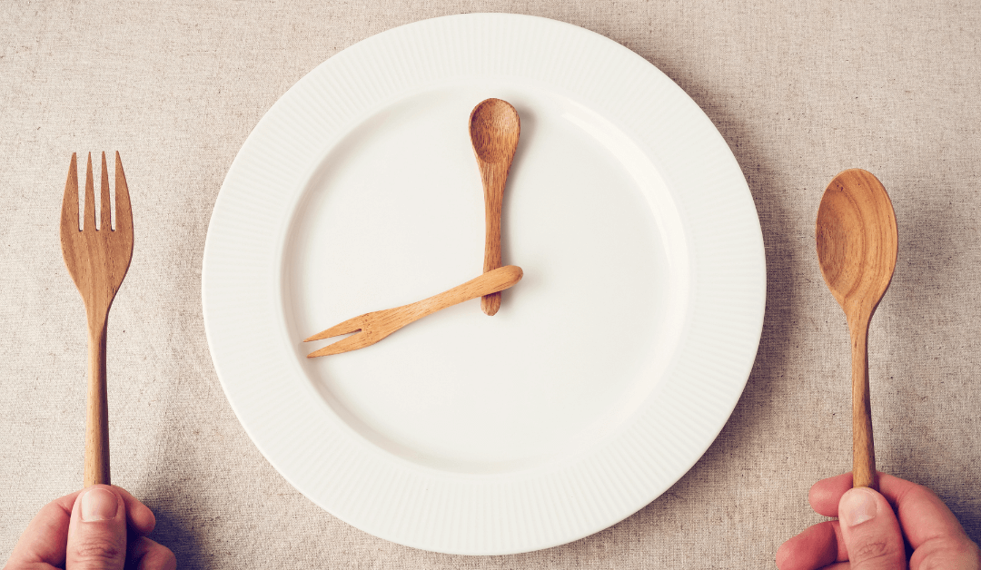 A plate, fork and spoon are laid out like a clock to symbolise intermittent fasting.